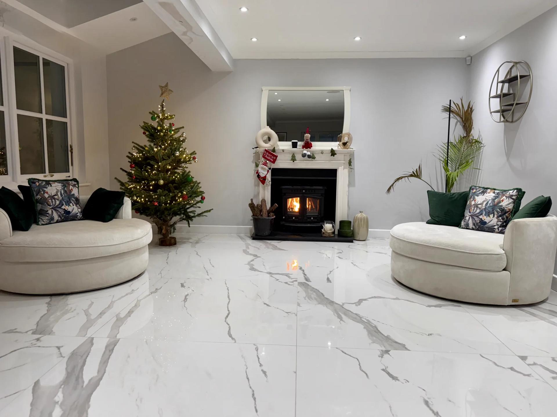 Lounge at Christmas: lit log-burner, curved sofas, marble floor