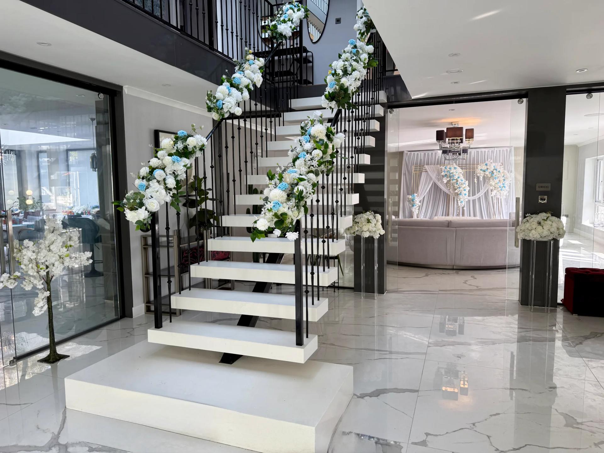 The floating stair dressed with white & blue floral garlands for a wedding